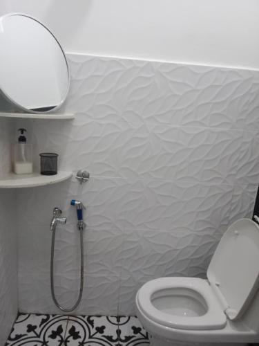 a bathroom with a white toilet and a shower at Rumah Comel Temerloh Studio in Temerloh