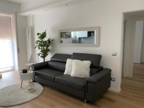 a black leather couch in a living room with a rug at HOME LEOPARDI humanitas,forum,ieo INTERO APPARTAMENTO in Rozzano