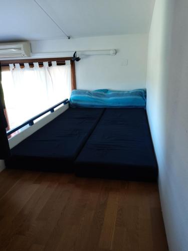 a small bed in a room with a window at Lulamax Sardegna in Budoni