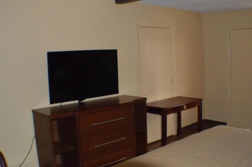 a bedroom with a television on a dresser with a bed at Sun Down Lodge in Locust Grove