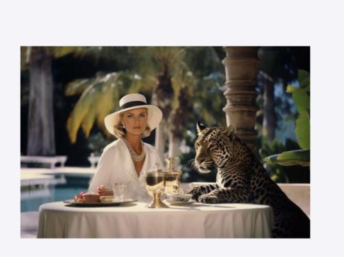 une femme dans un chapeau assise à une table avec un léopard dans l'établissement Joli Studio - Place Morny, à Deauville