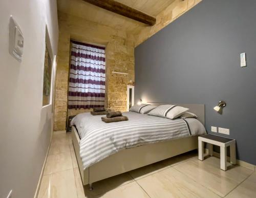 a bedroom with a large bed and a window at Great Siege Apartment in Senglea