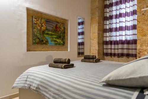 una cama con dos almohadas encima en Great Siege Apartment, en Senglea
