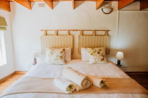 a bedroom with a large white bed with two pillows at The Loft House in Graaff-Reinet