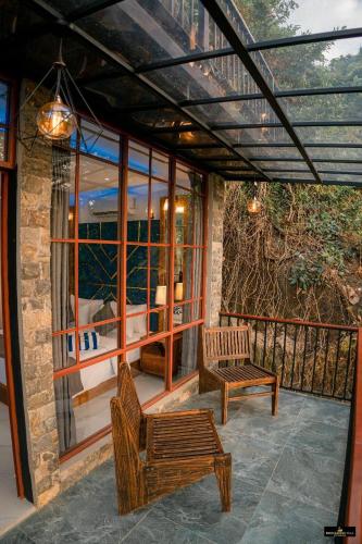 a screened in porch with two chairs and a bench at Rock Garden Villa Pinnawala in Rambukkana