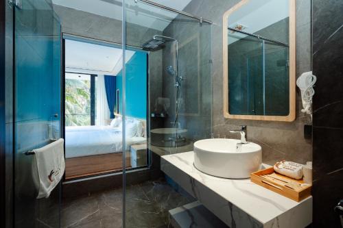a bathroom with a sink and a glass shower at Tam Coc Wonderland Lodge in Ninh Binh