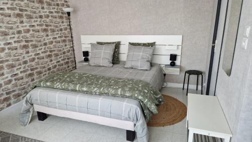 a bedroom with a bed and a brick wall at Appartement centre ville avec parking privatif in Dijon