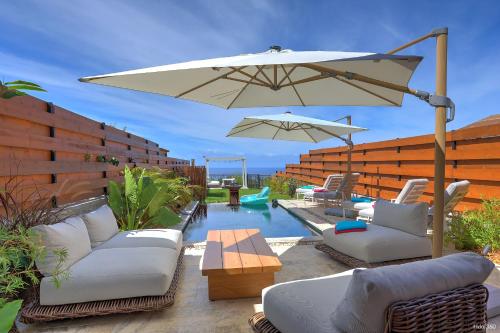 a patio with chairs and an umbrella and a pool at Villa Kintana - Piscine - SPA - Prestations 5 Etoiles in Petite Île