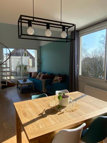un salon avec une table en bois et un canapé dans l'établissement Appartement 4p avec garage privé, à Dijon