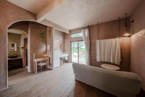 a living room with a couch and a sink at 宮古島の自然豊かで静かなエリアroom1オリジナルインテリア小物が溢れる空間 in Miyako Island