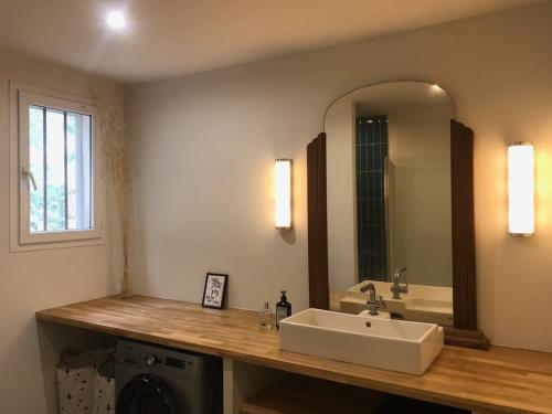 une salle de bain avec un lavabo et un miroir dans l'établissement Villa dans la nature, à Gémenos