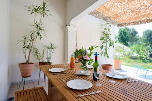 une table en bois avec des assiettes et des verres à vin dessus dans l'établissement Villa dans la nature, à Gémenos