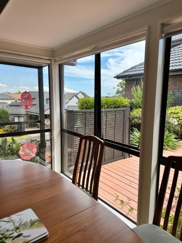 a dining room with a view of a deck at A Home Away from Home - Bucklands Beach Luxury 3-Bedroom Garden Villa in Auckland