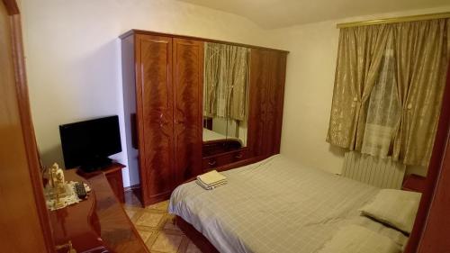 a small bedroom with a bed and a television at Casa di Vacanza Boccasette in Palazzo Rastelli