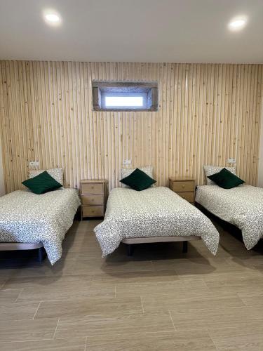 a room with three beds with green pillows at Forno House - Quarto peregrinos Caminho Santiago in Âncora