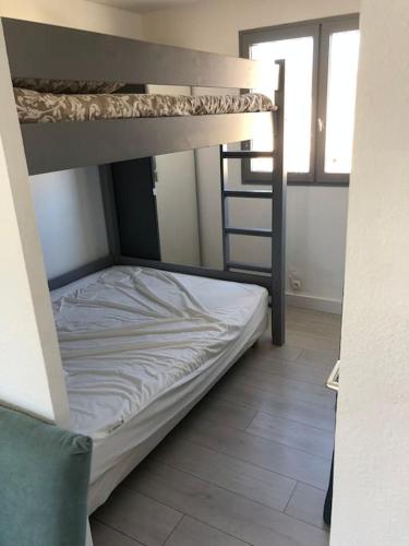 une chambre avec deux lits superposés dans une pièce dans l'établissement Appartement T2 face a l etang sans vis a vis, à Marseillan