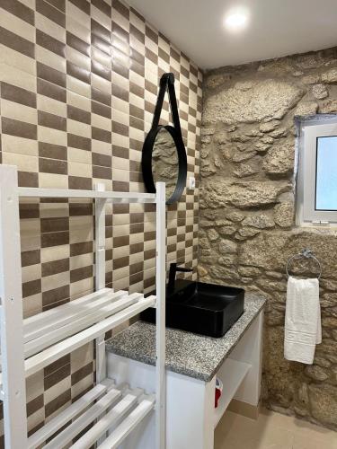 a bathroom with a sink and a stone wall at Forno House - Quarto peregrinos Caminho Santiago in Âncora