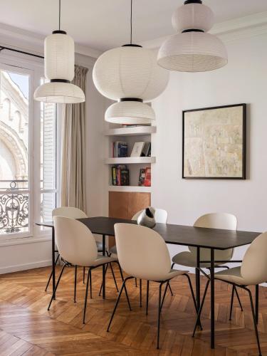 une salle à manger avec une table et des chaises noires dans l'établissement Appartement familial conçu par un architecte, à Levallois-Perret