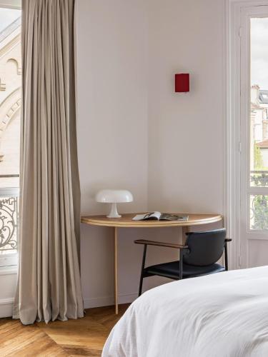 - une chambre avec un bureau, un lit et une fenêtre dans l'établissement Appartement familial conçu par un architecte, à Levallois-Perret