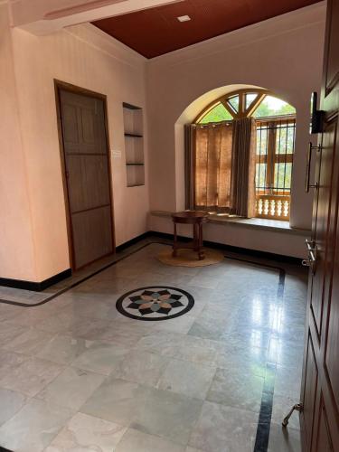 an empty living room with a table and a window at EcoMinimalist Home by the River in Seringapatam
