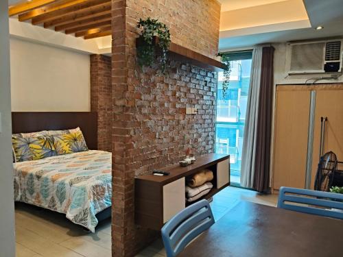 a bedroom with a bed and a brick wall at LDN Secret Crib 7D-Two palm tree across NAIA Terminal 3 in Manila