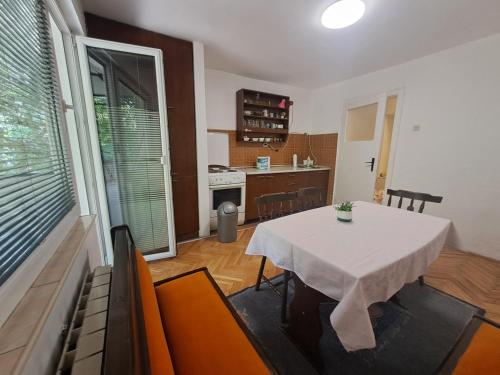 a dining room with a table and a kitchen at Dramski apartment in Skopje