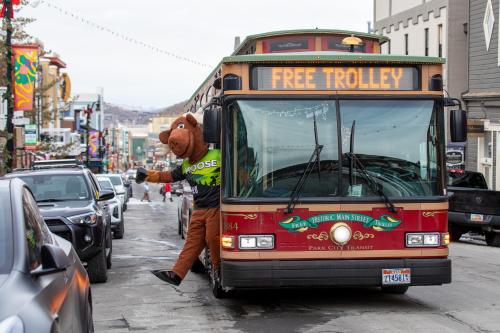 a man dressed in a mascot standing next to a bus at Black Rock Ridge 14202 by Moose Management in Park City