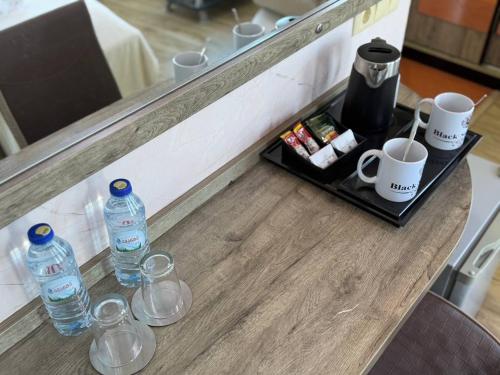 a counter with two bottles of water and cups at Black Sea Star Batumi in Batumi