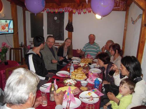 a group of people sitting around a table eating at Lile Pestani Accommodation in Peštani