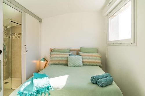 - une petite chambre avec un lit vert et des oreillers dans l'établissement Olyvea suite méditerranéenne avec vue sur le port et la mer, à 2 minutes des plages, à Vallauris