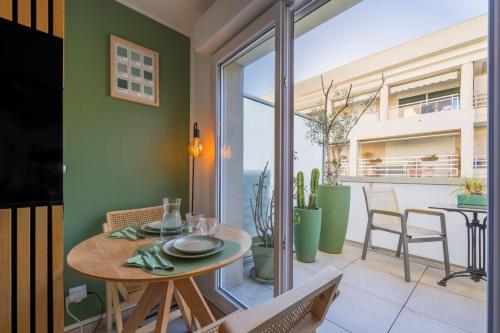 une salle à manger avec une table et un balcon dans l'établissement Olyvea suite méditerranéenne avec vue sur le port et la mer, à 2 minutes des plages, à Vallauris