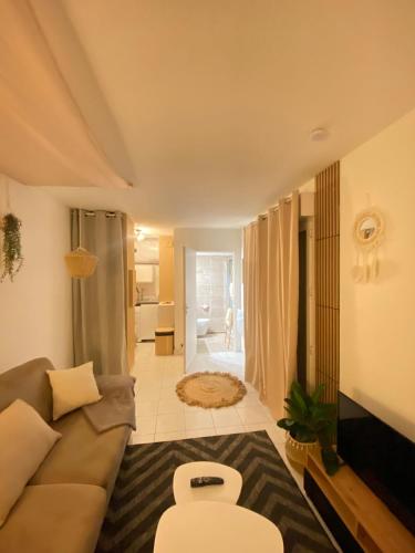 un salon avec un canapé et une salle de bains. dans l'établissement Studio Boho Chic - Proche de la mer, à Nice