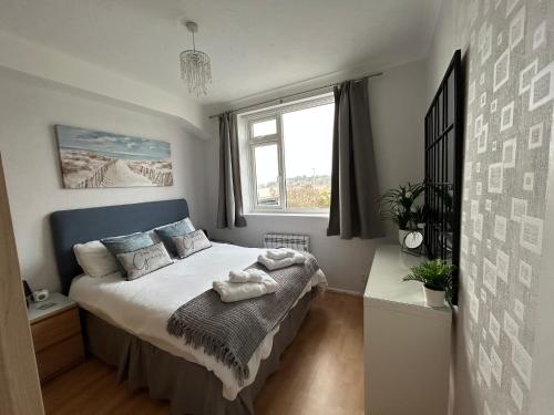a bedroom with a bed and a window at SHOREBANKS - Harbour View Apartment in Sandbanks. in Sandbanks