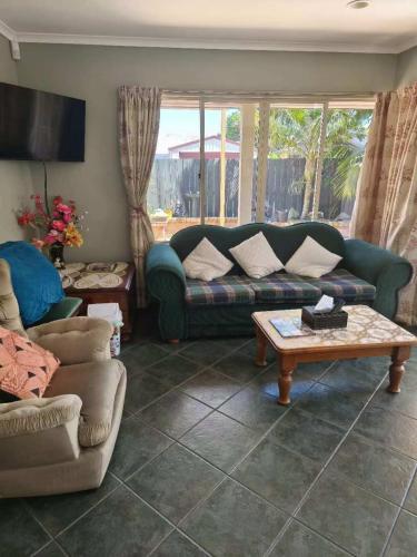 a living room with a couch and a table at Susan's Holiday House in Hamilton