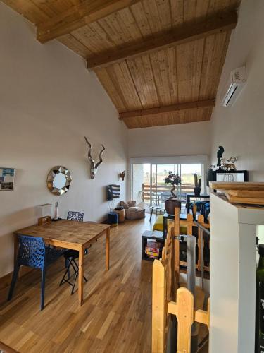 un salon avec une table et des chaises en bois dans l'établissement Appartement neuf 6 couchages 50 metres de la plage, à Gruissan