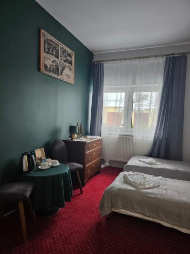 a bedroom with a bed and a desk and a table at Zamek Międzylesie in Międzylesie
