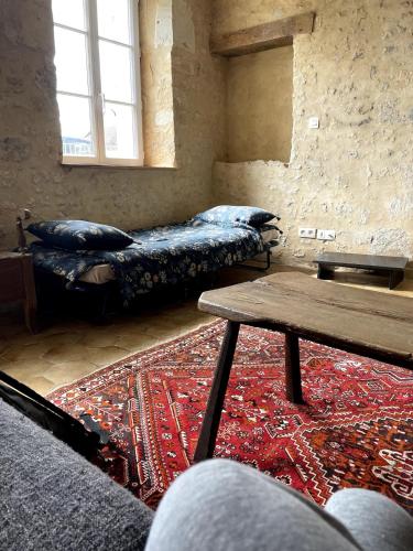 Cette chambre comprend un canapé, une table et un tapis. dans l'établissement Charming Percheron house, à Nocé