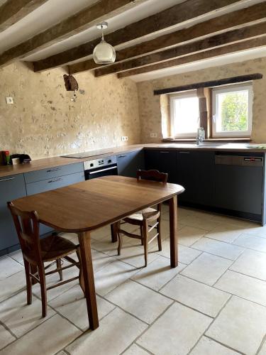 Il comprend une cuisine avec une table et des chaises en bois. dans l'établissement Charming Percheron house, à Nocé