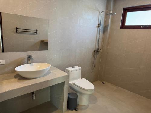 a bathroom with a white sink and a toilet at Villa The Palm Sip Song in Koh Phangan