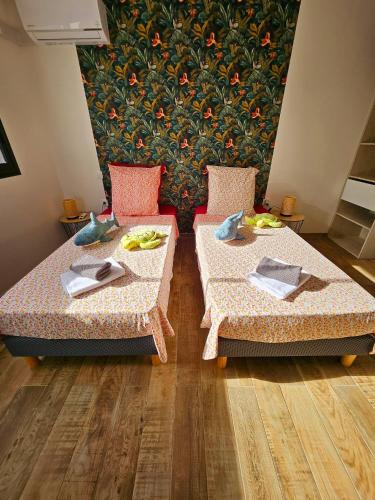 two beds in a room with plates of food on them at L'Anse des Baleines, Vue panoramique sur l'océan, Piscine & Confort 4 étoiles in Petite Île