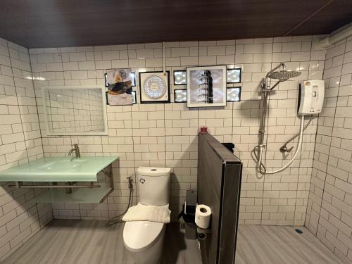 a bathroom with a toilet and a sink and a shower at Baan Chiang Dao in Chiang Dao