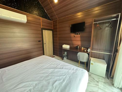 a bedroom with a white bed and a desk at Baan Chiang Dao in Chiang Dao