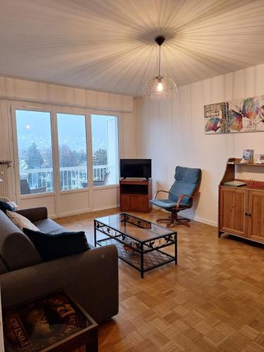 a living room with a couch and a table at Chez Isabelle et Florent - Logis Familial du Lac in Annecy