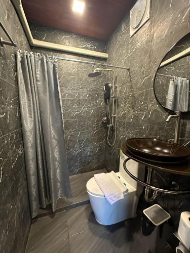 a bathroom with a shower and a toilet and a sink at Baan Chiang Dao in Chiang Dao