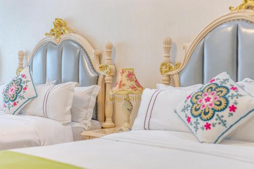 a bedroom with two beds with white pillows at WAIFIDEN Guangzhou HaiZhu Square WanYi Apartment in Guangzhou