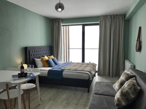 a bedroom with a bed and a table and a couch at New Gudauri GN Apartments in Atrium in Gudauri