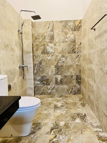 a bathroom with a toilet and a shower at Sithuka Villa Bentota in Bentota