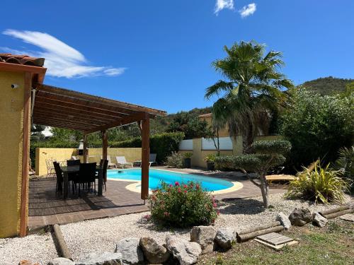 un patio avec une table et des chaises à côté d'une piscine dans l'établissement Villa l Olivier avec piscine privée, à Les Cluses