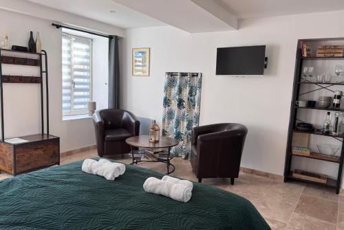 a bedroom with a bed and two chairs and a table at Escapade à Pommard in Pommard