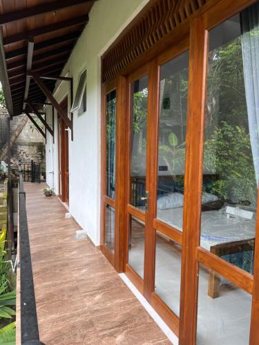 a house with wooden doors and a porch at Mahaweli Haven in Nattarampota